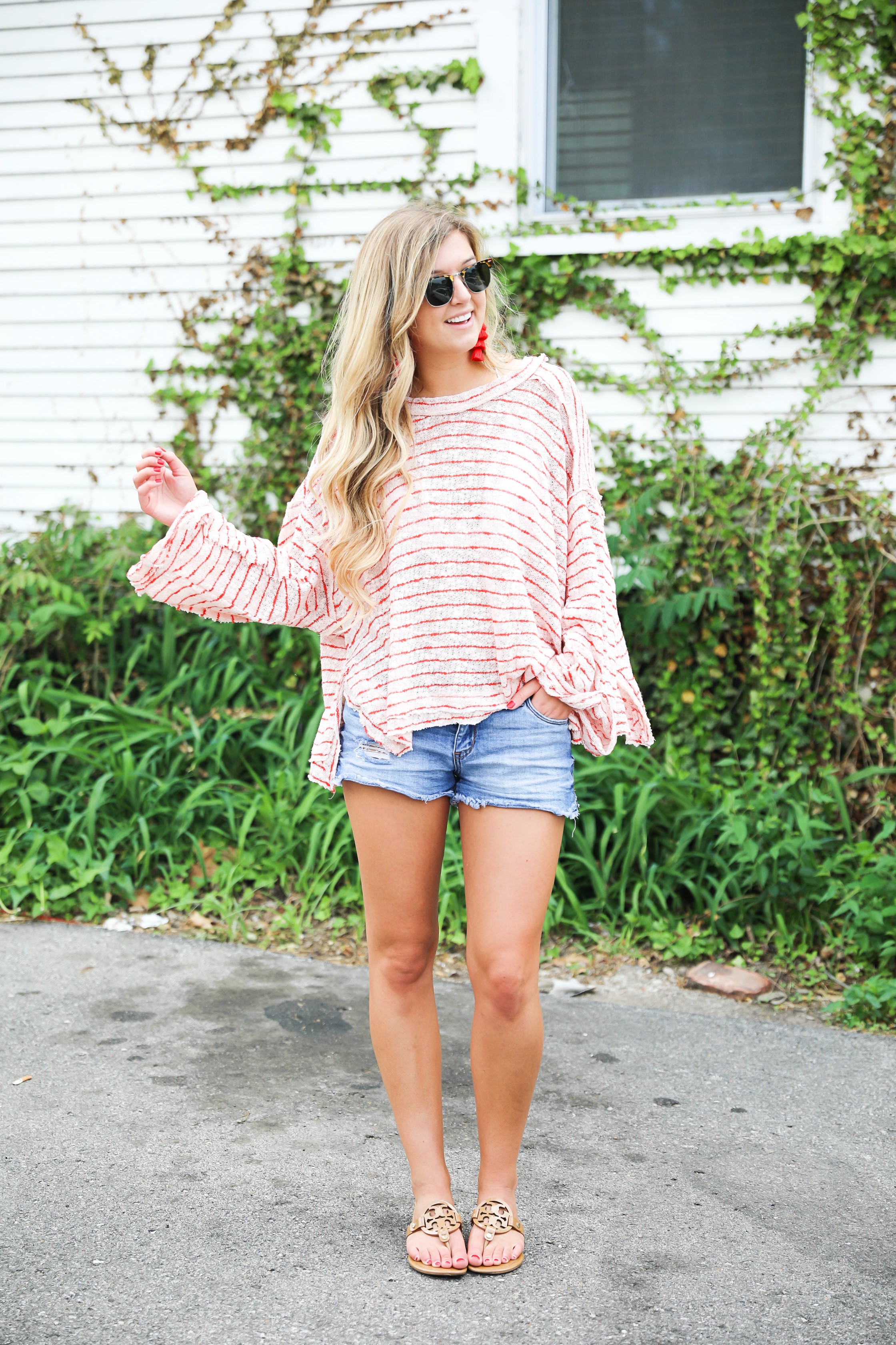 Striped red free people sweater with denim shorts and red tassel earrings! Perfect sweater for summer and days at the beach! Light weight summer sweater! Fourth of july outfit idea on fashion blog daily dose of charm by lauren lindmark