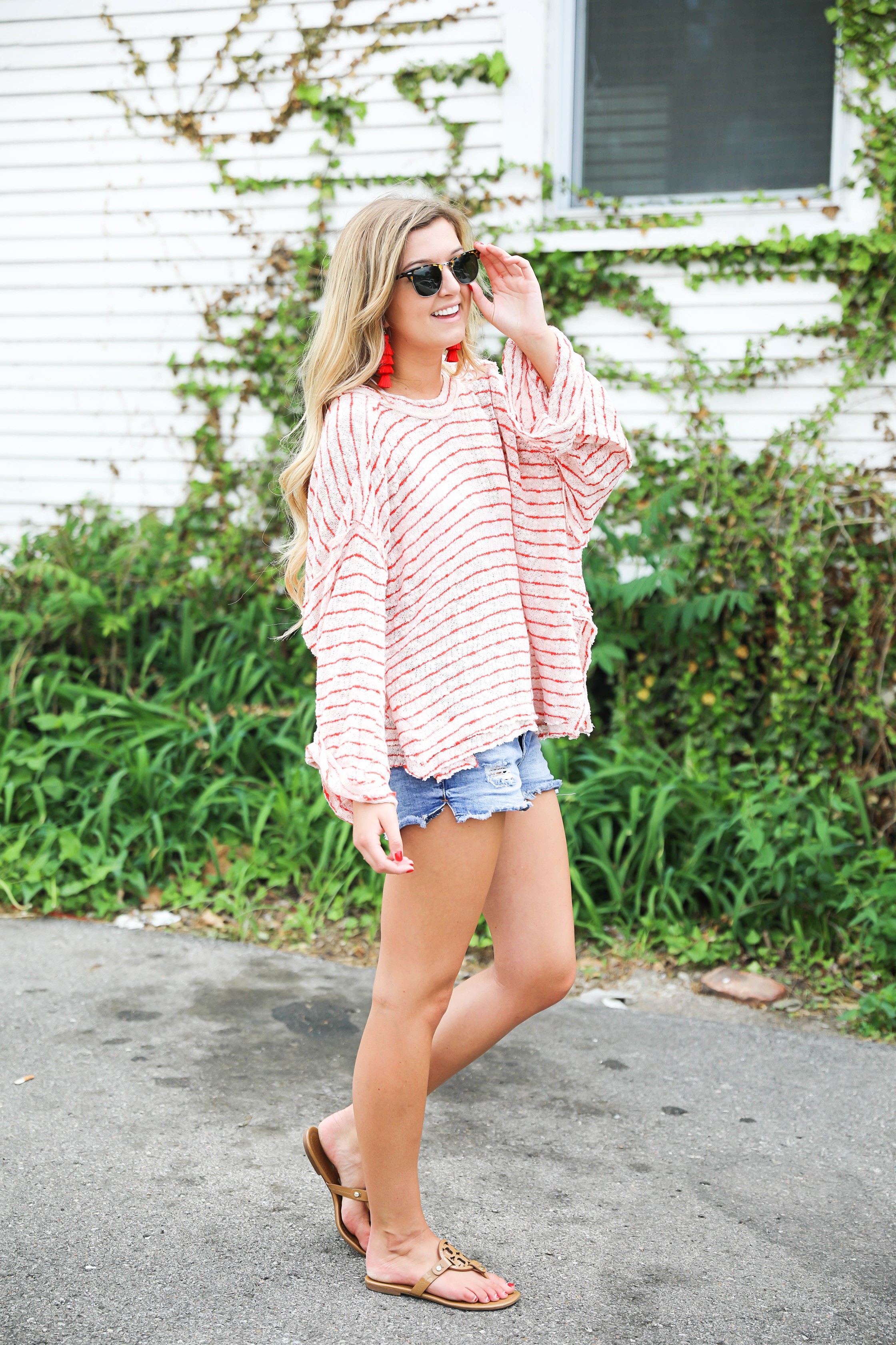 Striped red free people sweater with denim shorts and red tassel earrings! Perfect sweater for summer and days at the beach! Light weight summer sweater! Fourth of july outfit idea on fashion blog daily dose of charm by lauren lindmark