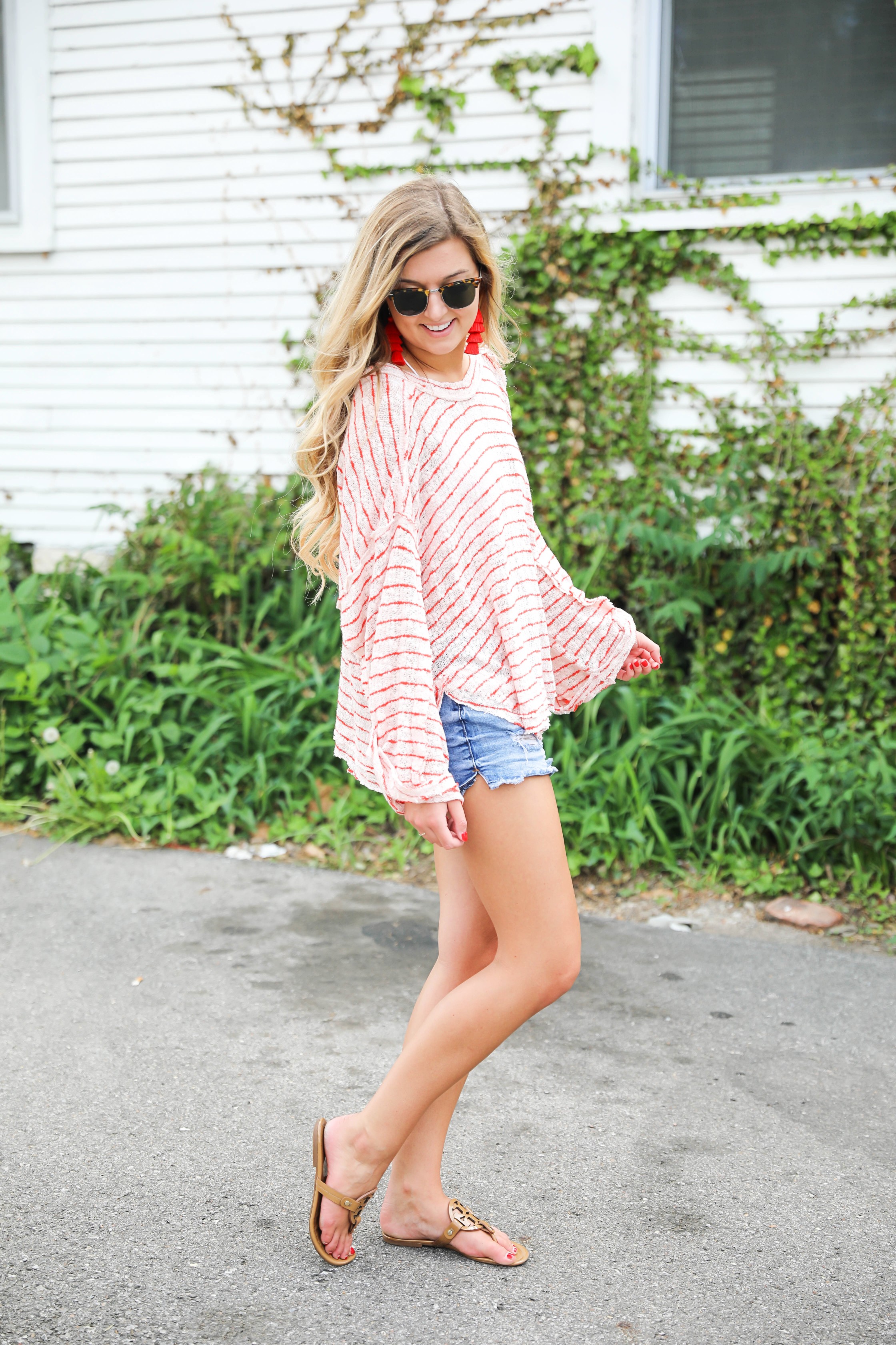 Striped red free people sweater with denim shorts and red tassel earrings! Perfect sweater for summer and days at the beach! Light weight summer sweater! Fourth of july outfit idea on fashion blog daily dose of charm by lauren lindmark
