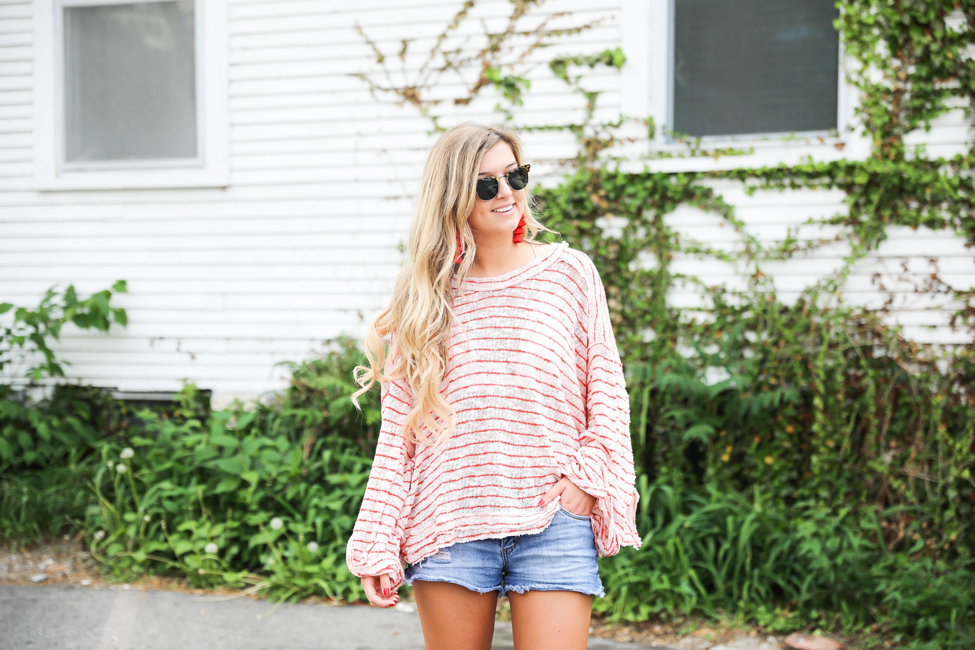 Striped red free people sweater with denim shorts and red tassel earrings! Perfect sweater for summer and days at the beach! Light weight summer sweater! Fourth of july outfit idea on fashion blog daily dose of charm by lauren lindmark