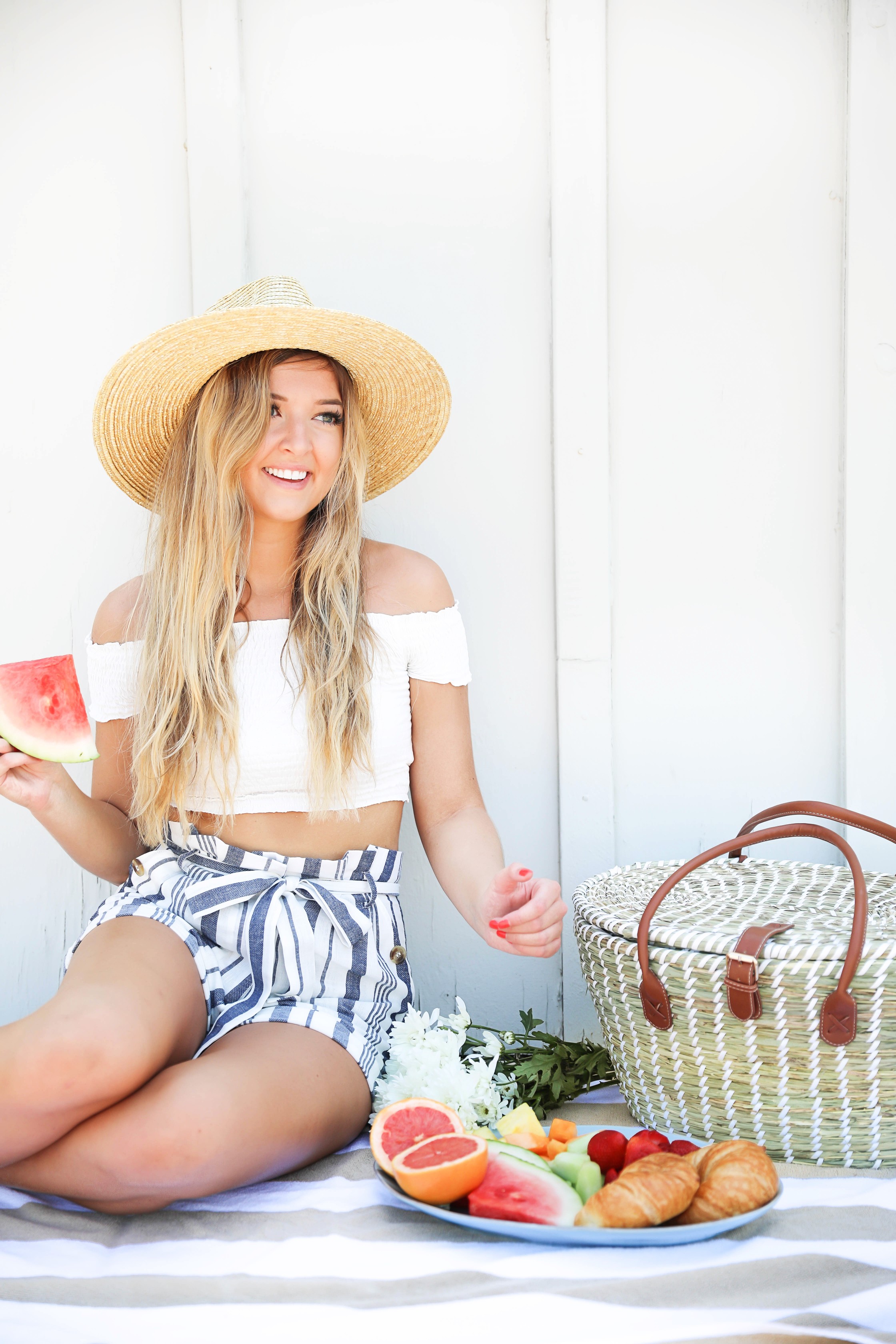 Summer picnic! A fun picnic with summer fruit and croissants! White off the shoulder crop top from Showpo paired with my favorite striped blue tied shorts from Nordstrom! I paired this look with a wide brim straw hat and my favorite Marc Fisher Espadrille wedges! This cute summer outfit is going to be on repeat! Details on fashion blog daily dose of charm by lauren lindmark