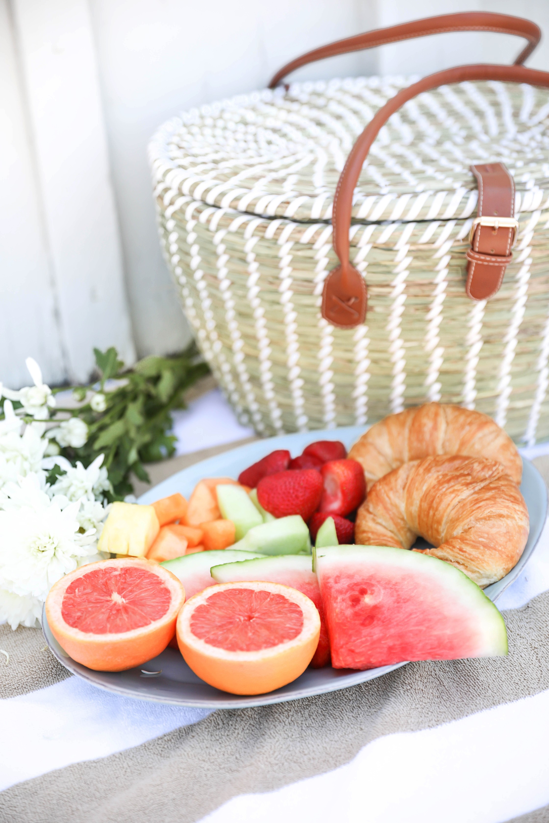 Summer picnic! A fun picnic with summer fruit and croissants! White off the shoulder crop top from Showpo paired with my favorite striped blue tied shorts from Nordstrom! I paired this look with a wide brim straw hat and my favorite Marc Fisher Espadrille wedges! This cute summer outfit is going to be on repeat! Details on fashion blog daily dose of charm by lauren lindmark