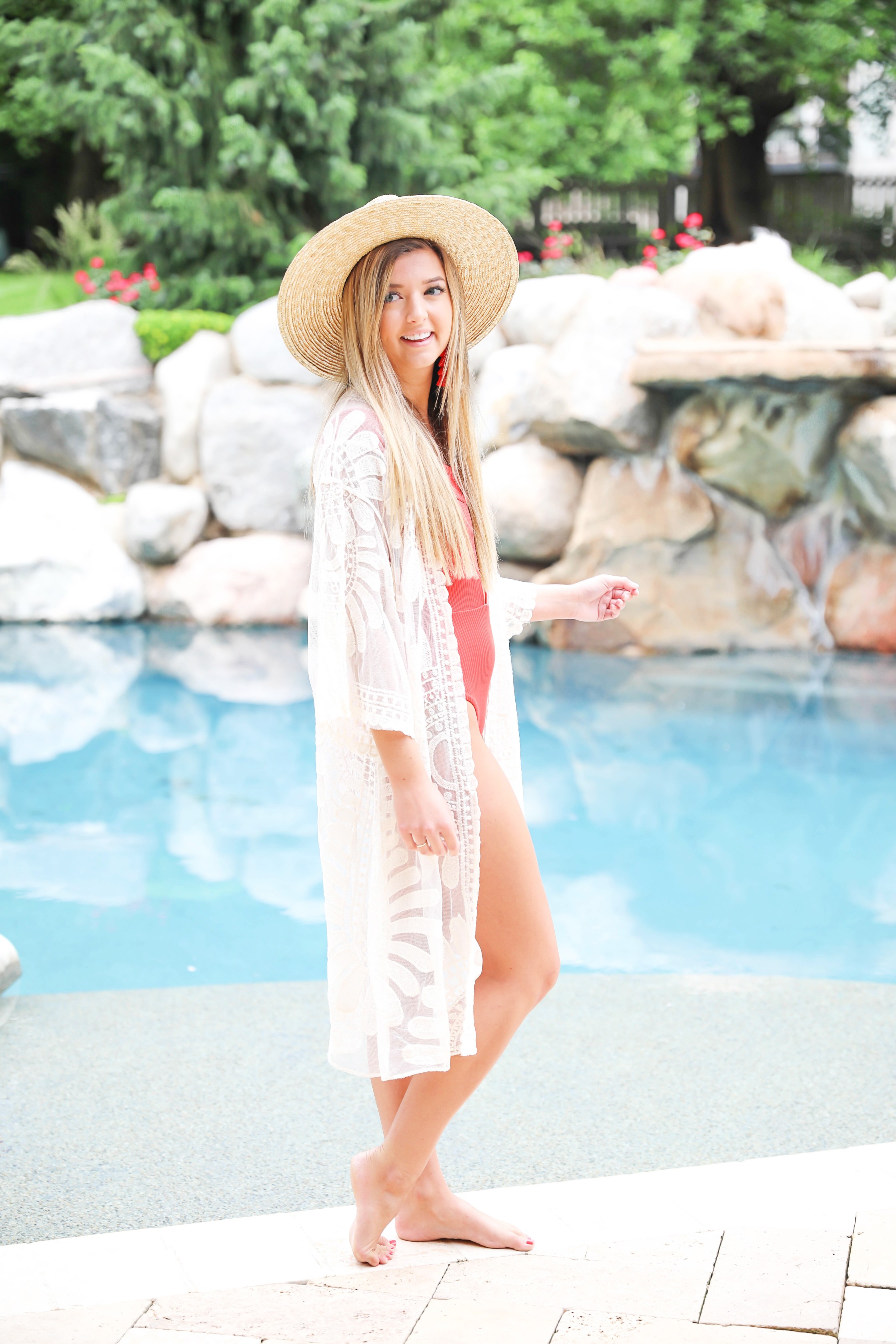 Hot red one piece! This adorable suit is reversible and also comes in white, yellow, and black! I paired this with my sheer mesh woven lace kimono and wide brim straw hat! Summer look by the pool! Details on fashion blog daily dose of charm by lauren lindmark
