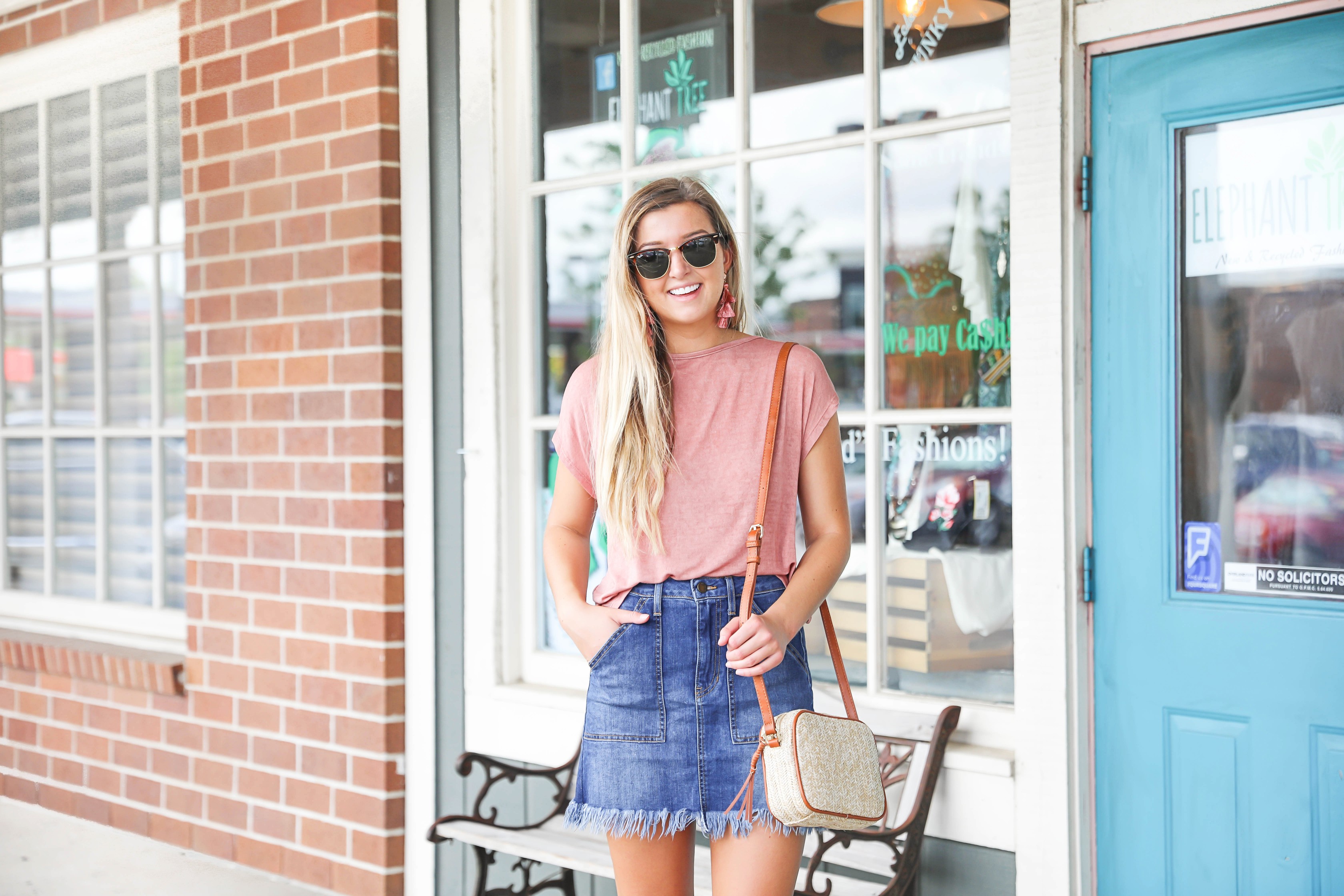Open back tops are so cute in the summer! This cinched and tied coral top is so cute with this frayed jean skirt! I finished off the look with my straw bag and marc fisher wedges! Details on this summer outfit are on fashion blog daily dose of charm by lauren lindmark