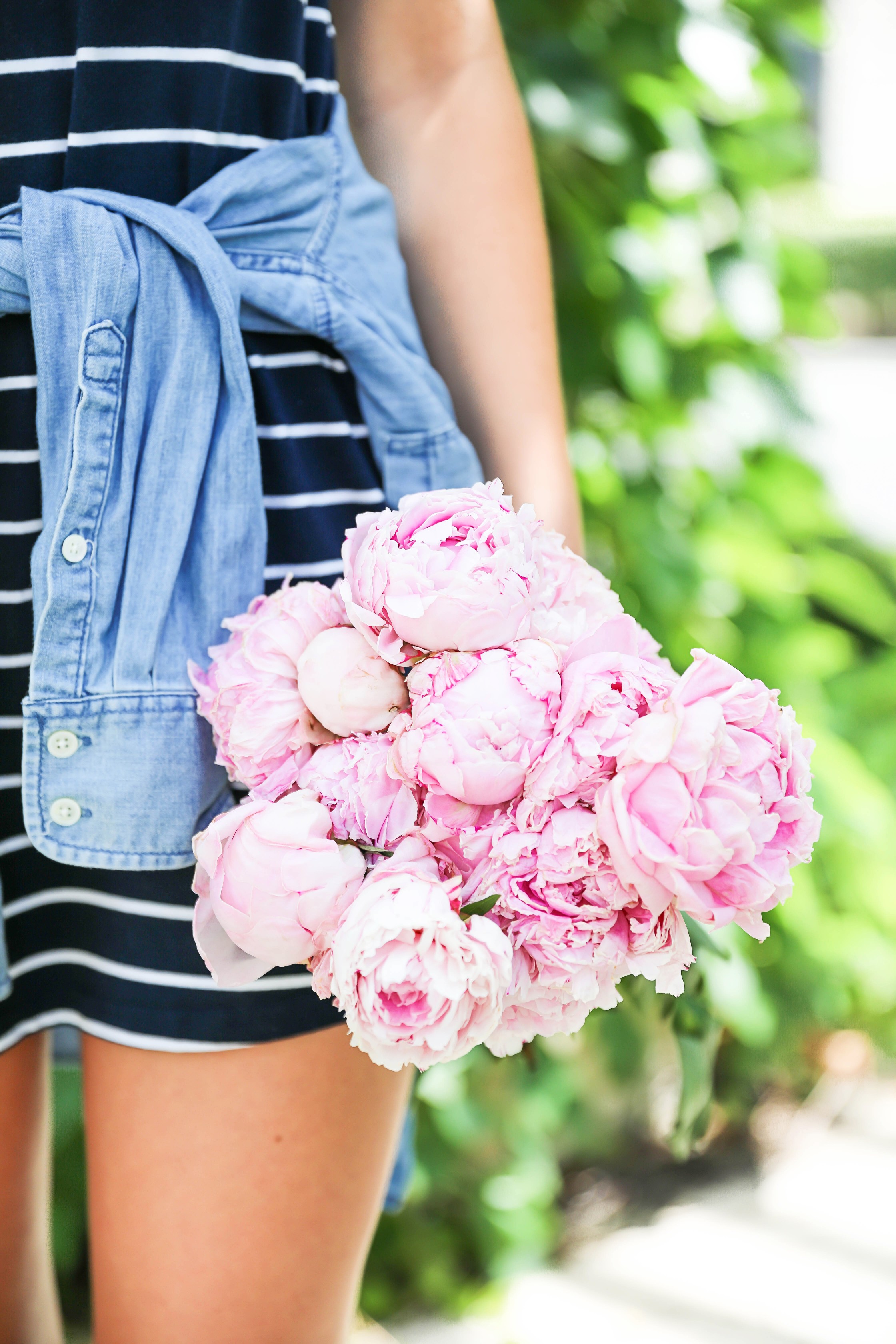 Striped t-shirt dress with a jean jacket tied around my waist! I love these pink peonies in the summer so they made the perfect "accessory" to this look! I finished the outfit with my braided suede shoes and large gold monogram necklace! Plus my new favorite Ray Ban black aviators! Details on this summer outfit are on fashion blog daily dose of charm by lauren lindmark