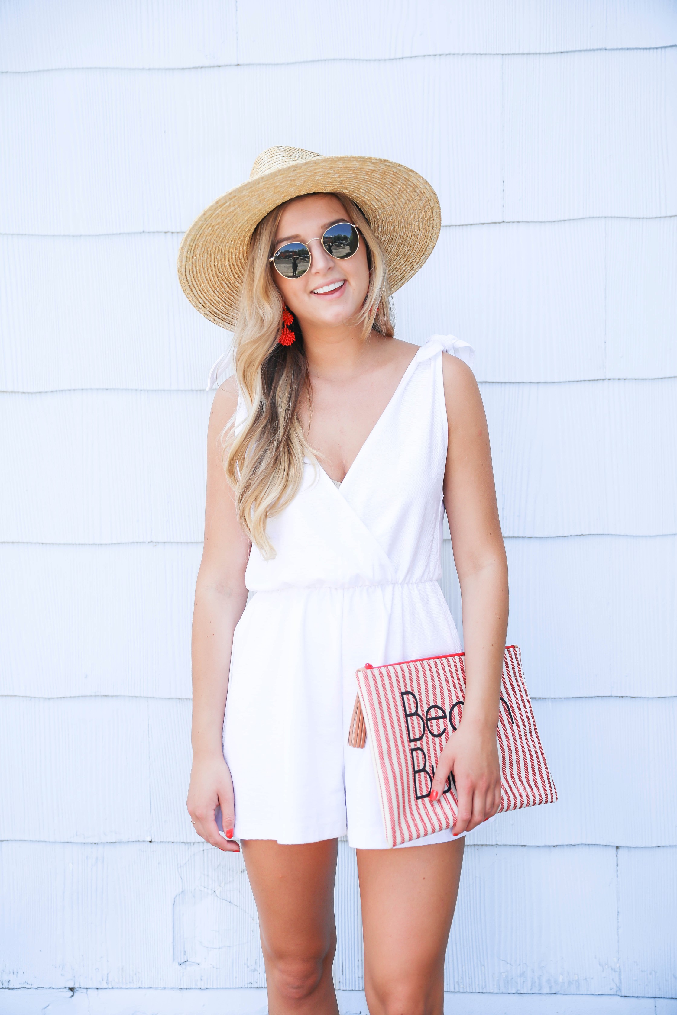 White romper for summer! This romper has a cute plunging neckline and ties on the shoulders. I love that it is linen because it won't wrinkle as easily! This romper and red statement earrings will be perfect for the Fourth of July! Paired with my cute nude heels and wide brimmed hat fashion! Details on fashion blog daily dose of charm by lauren lindmark