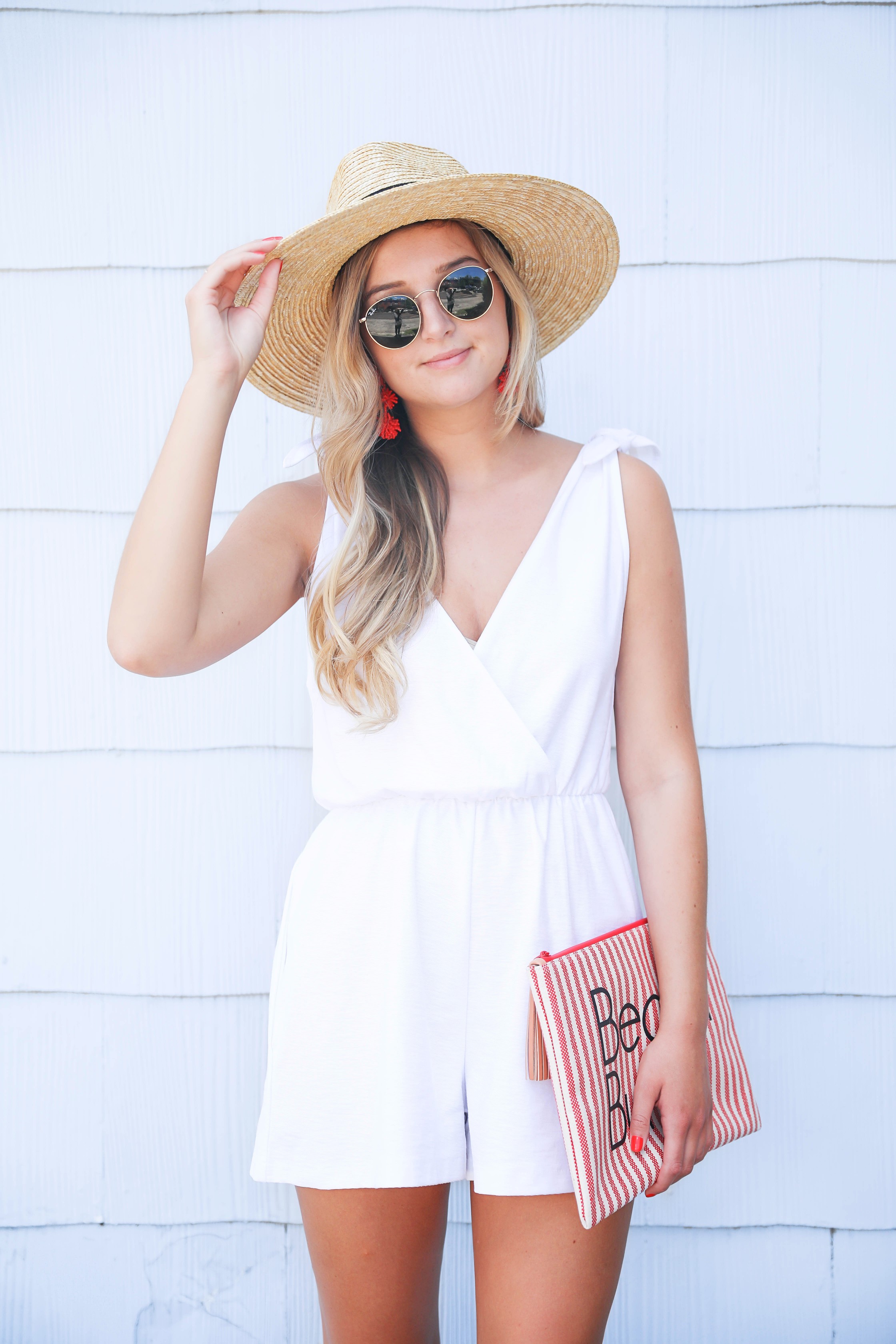 White romper for summer! This romper has a cute plunging neckline and ties on the shoulders. I love that it is linen because it won't wrinkle as easily! This romper and red statement earrings will be perfect for the Fourth of July! Paired with my cute nude heels and wide brimmed hat fashion! Details on fashion blog daily dose of charm by lauren lindmark