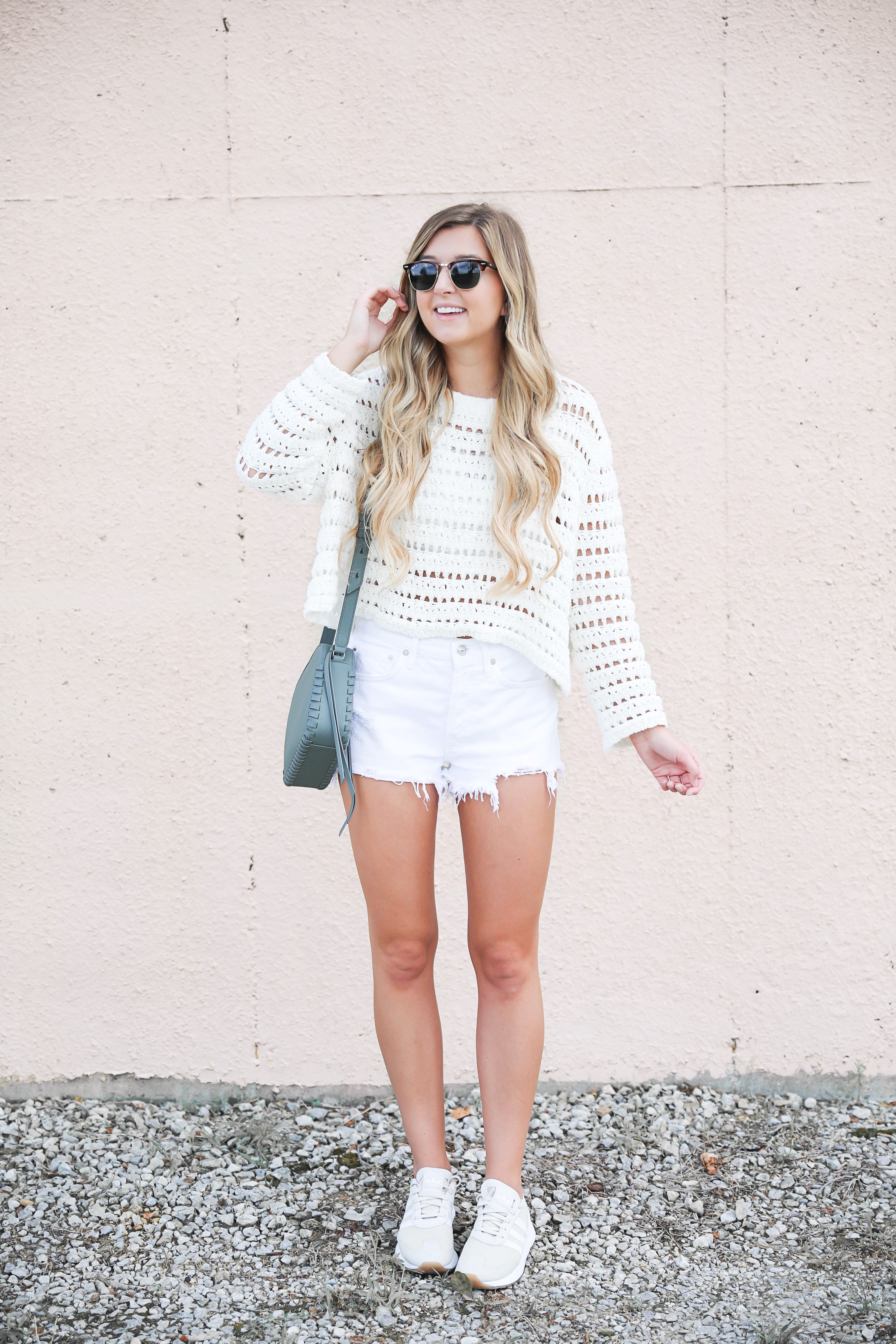 See through holy ivory sweater by ASTR perfect for summer! Paired with my favorite AGOLDE white shorts and new tan Adidas sneakers that are a part of the Nordstrom Sale! I am also wearing my allsaints blue bag that is from the nsale! Details on fashion blog daily dose of charm by lauren lindmark