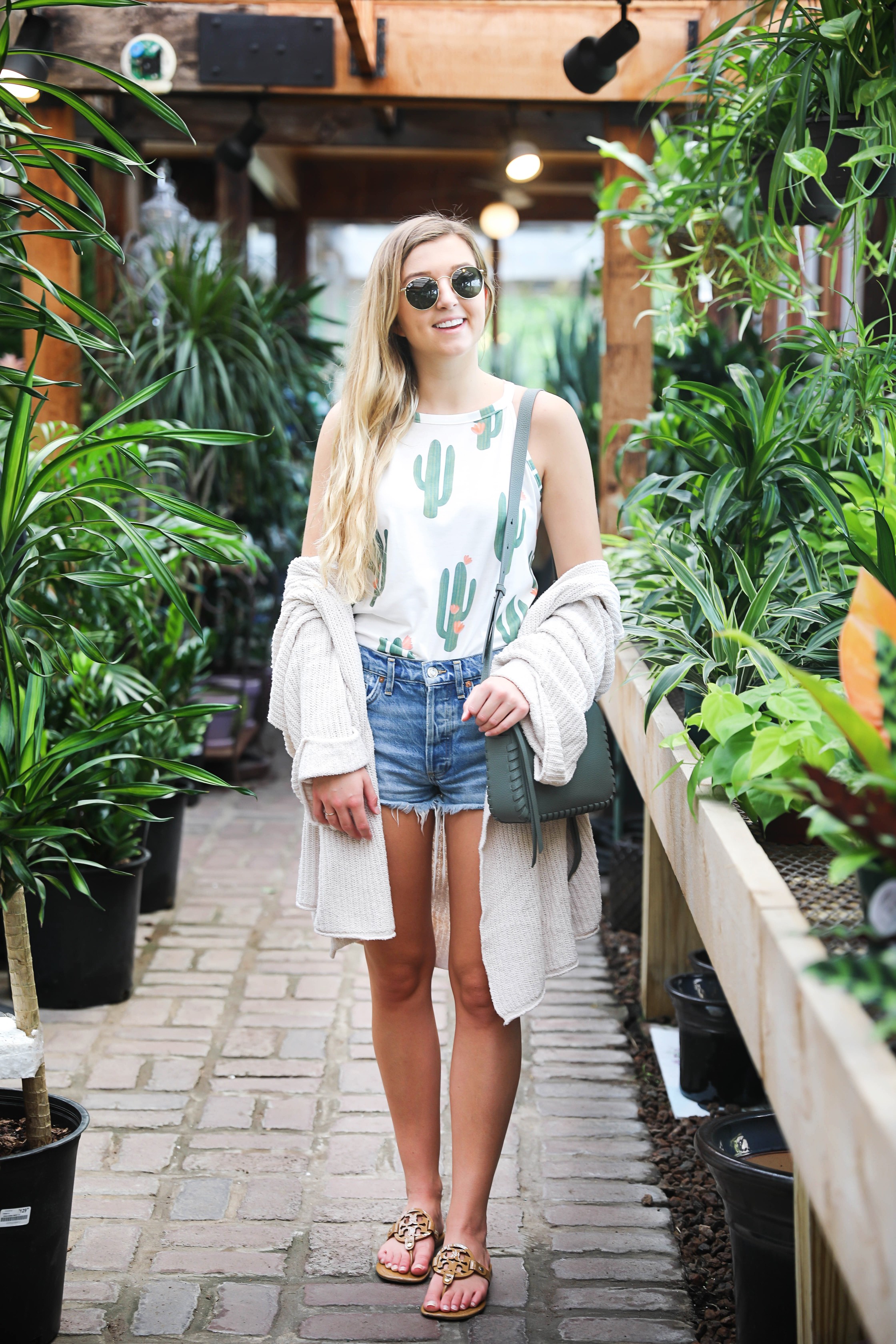 Cutest cactus top! Not only is it adorable, but it's inexpensive! I paired them with jean shorts, my favorite cream free people cardigan, my new allsaints bag, Tory Burch Millers, and Ray Ban sunglasses! The cutest summer outfit shot at a flower and plant nursery! Details on fashion blog daily dose of charm by lauren lindmark