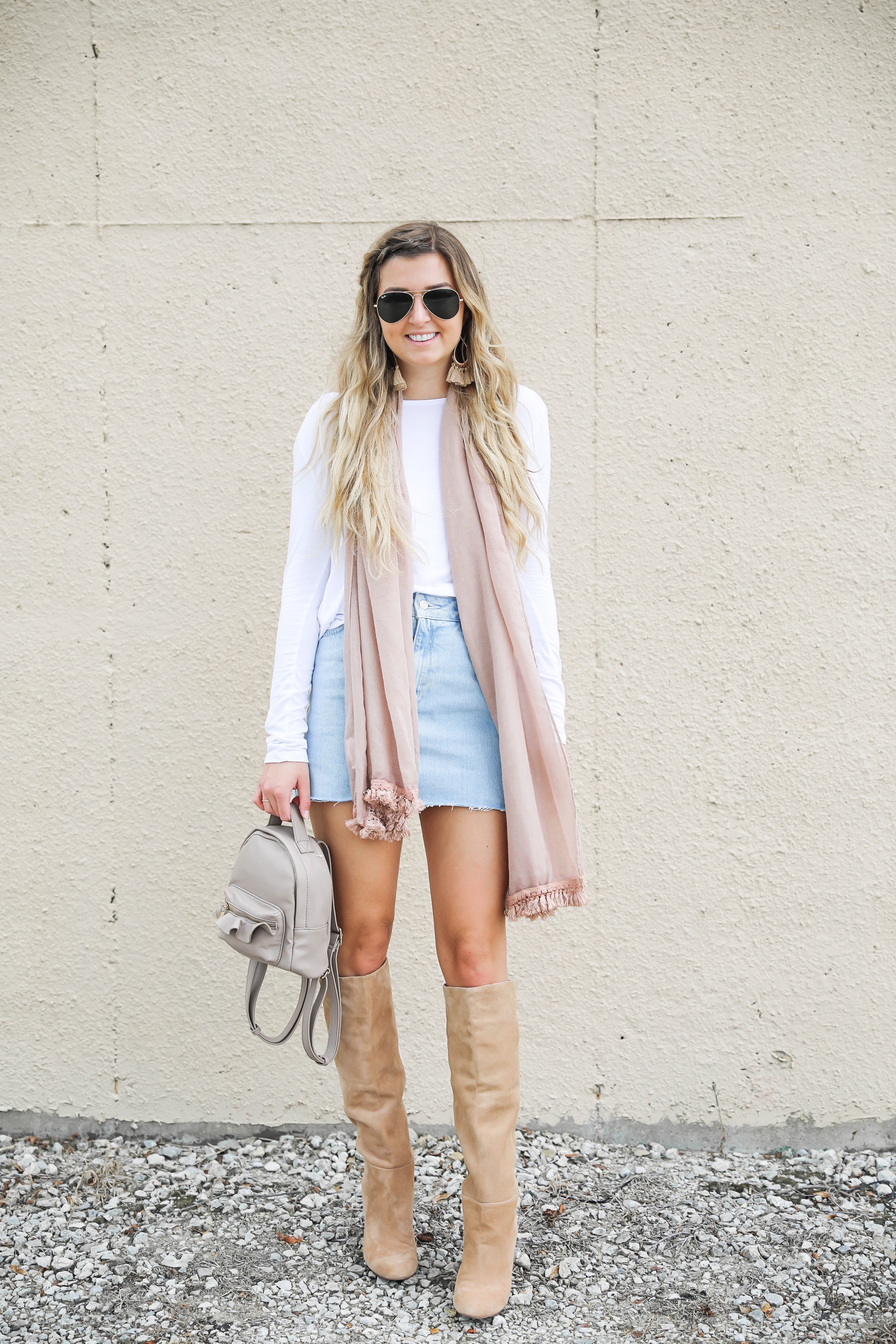 Light denim skirt with a long sleeve white t-shirt! The white t-shirt is open back and only $15! I am obsessed with this pink fringe scarf and these tan booties that totally complete the fall outfit! Details on daily dose of charm by lauren lindmark
