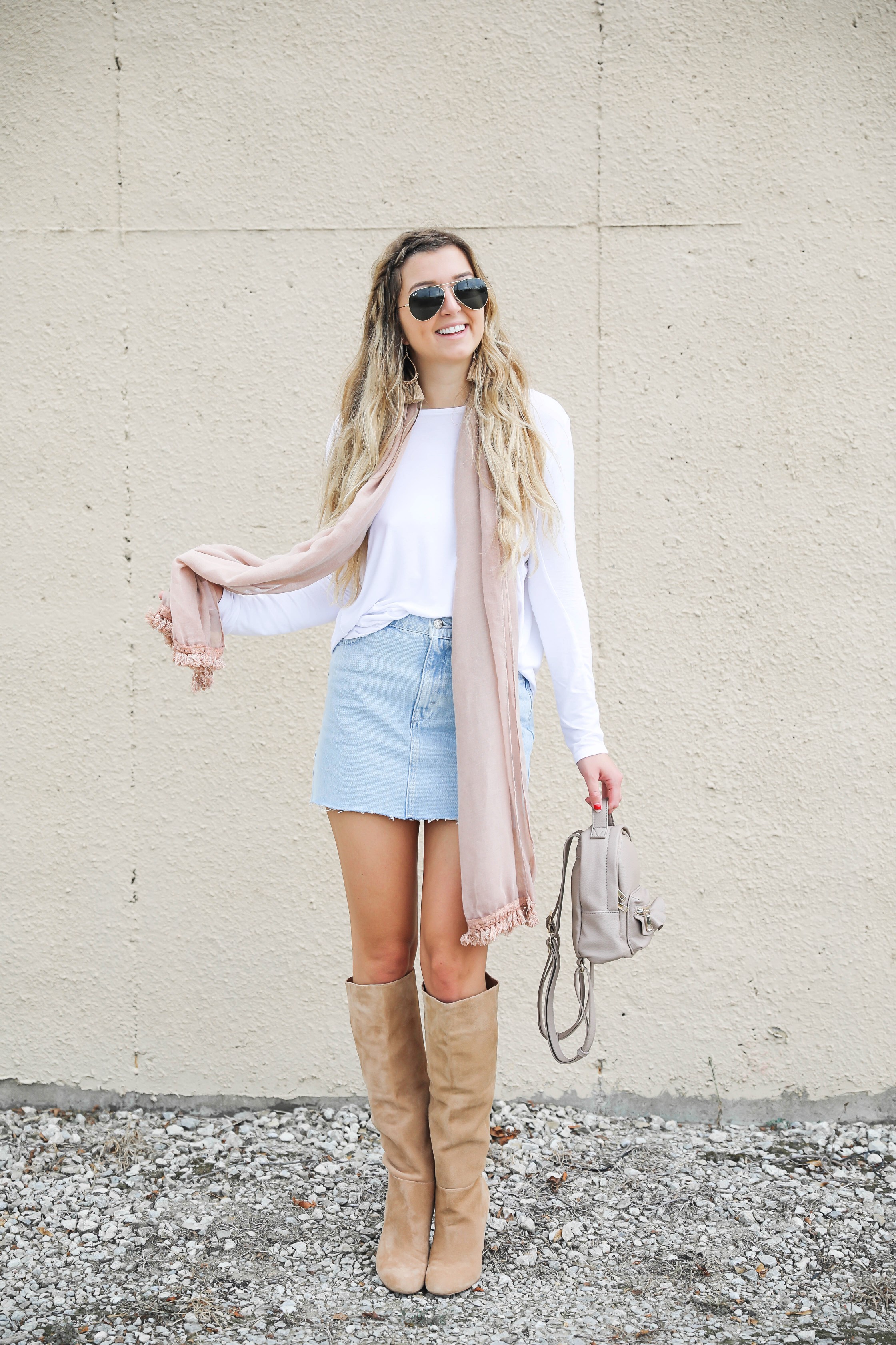 Light denim skirt with a long sleeve white t-shirt! The white t-shirt is open back and only $15! I am obsessed with this pink fringe scarf and these tan booties that totally complete the fall outfit! Details on daily dose of charm by lauren lindmark