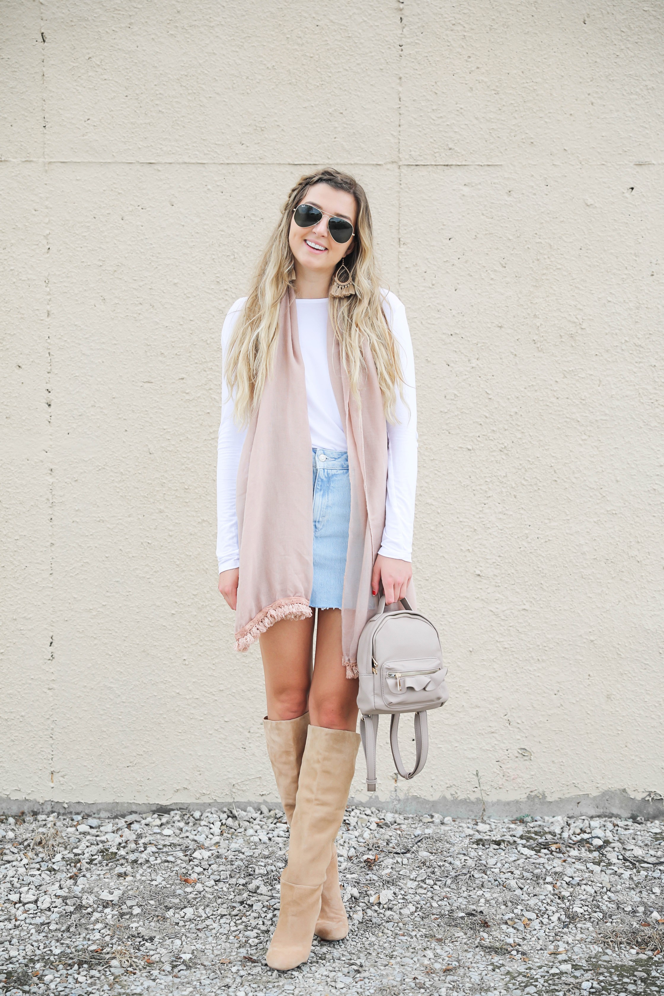 Light denim skirt with a long sleeve white t-shirt! The white t-shirt is open back and only $15! I am obsessed with this pink fringe scarf and these tan booties that totally complete the fall outfit! Details on daily dose of charm by lauren lindmark