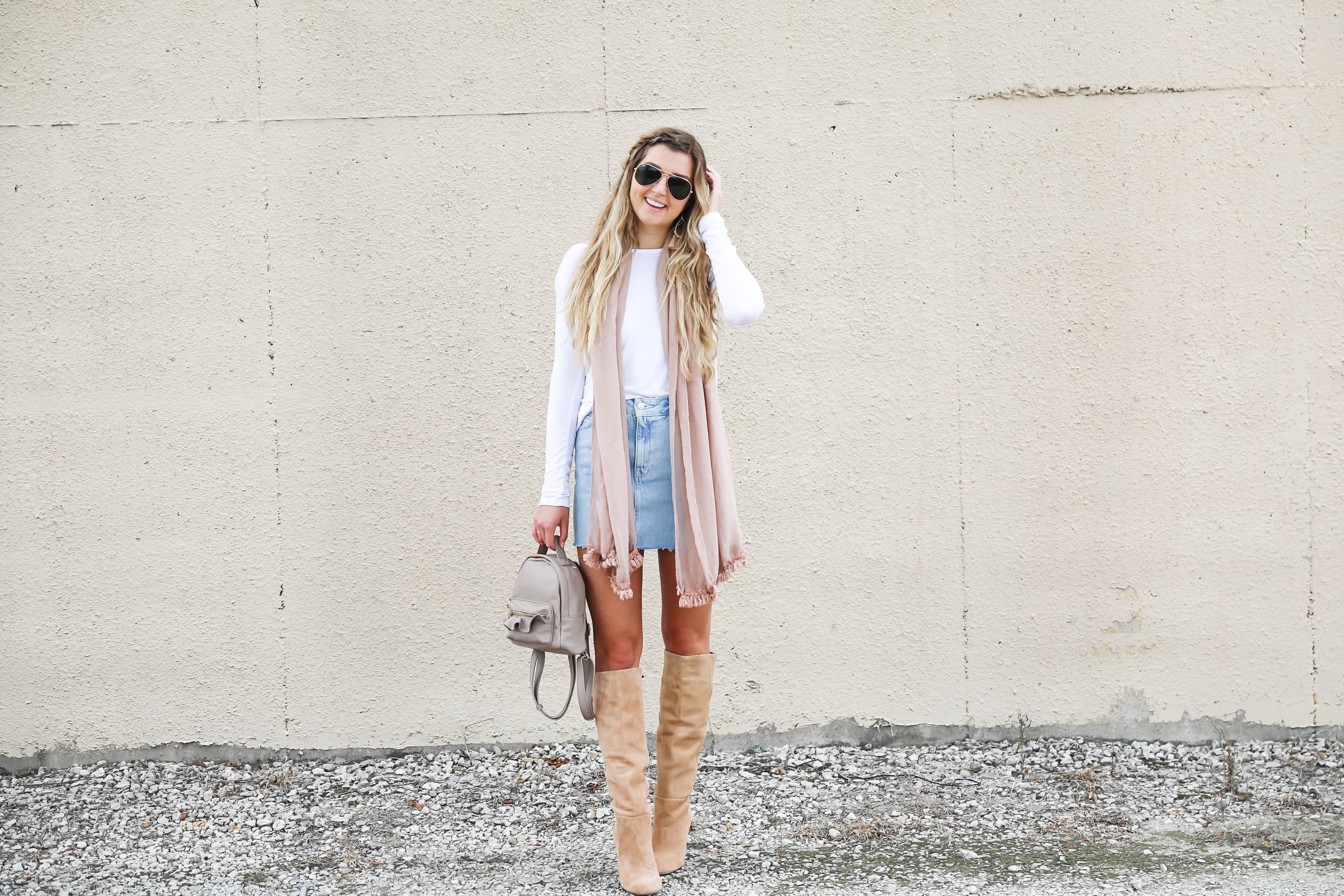 Light denim skirt with a long sleeve white t-shirt! The white t-shirt is open back and only $15! I am obsessed with this pink fringe scarf and these tan booties that totally complete the fall outfit! Details on daily dose of charm by lauren lindmark