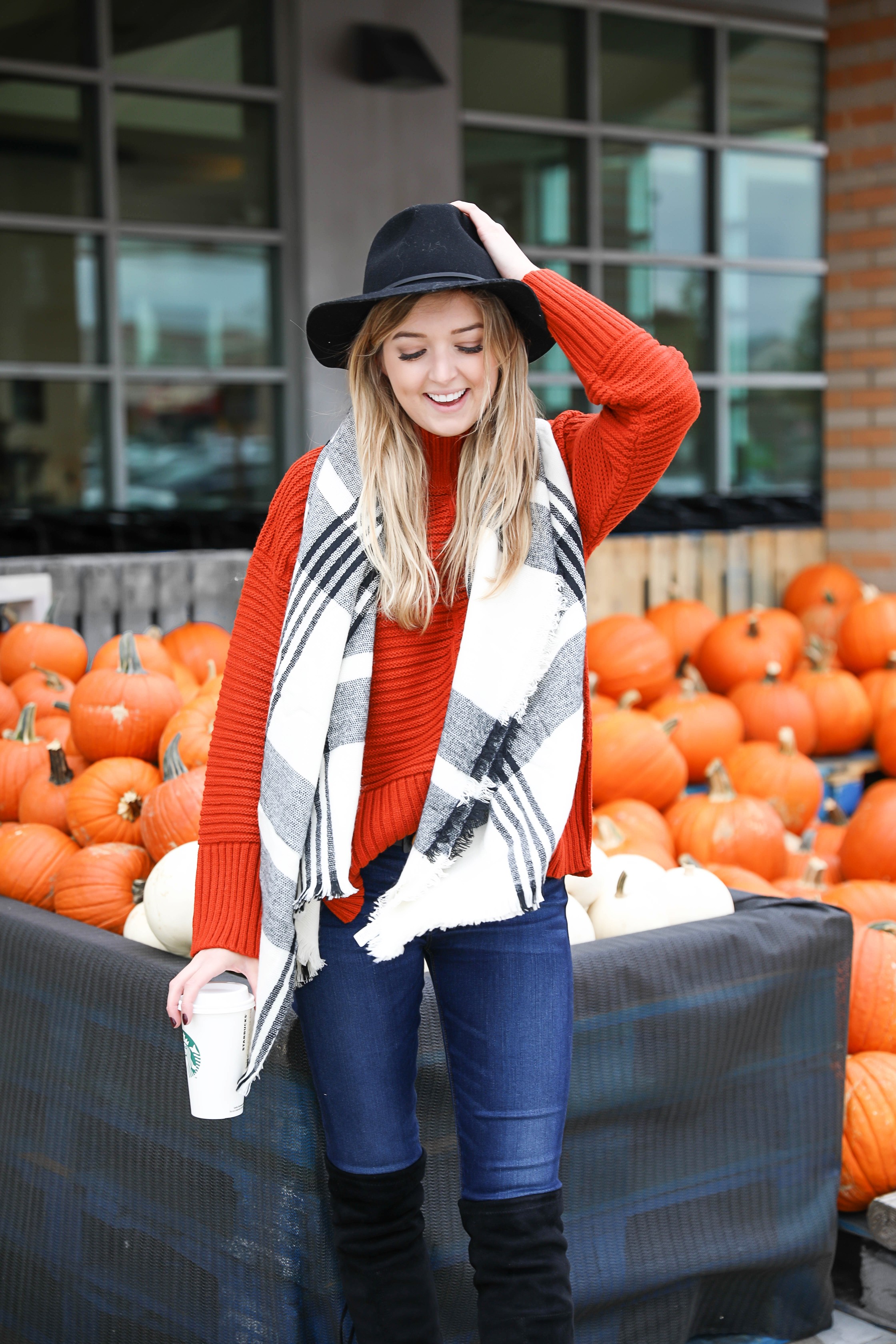 Orange Topshop sweater with a cute black and white scarf that doubles as a poncho! I paired this fall look with these $40 over the knee boots and my favorite black felt hat! Cutest fall outfit ideas on fashion blog daily dose of charm by lauren lindmark