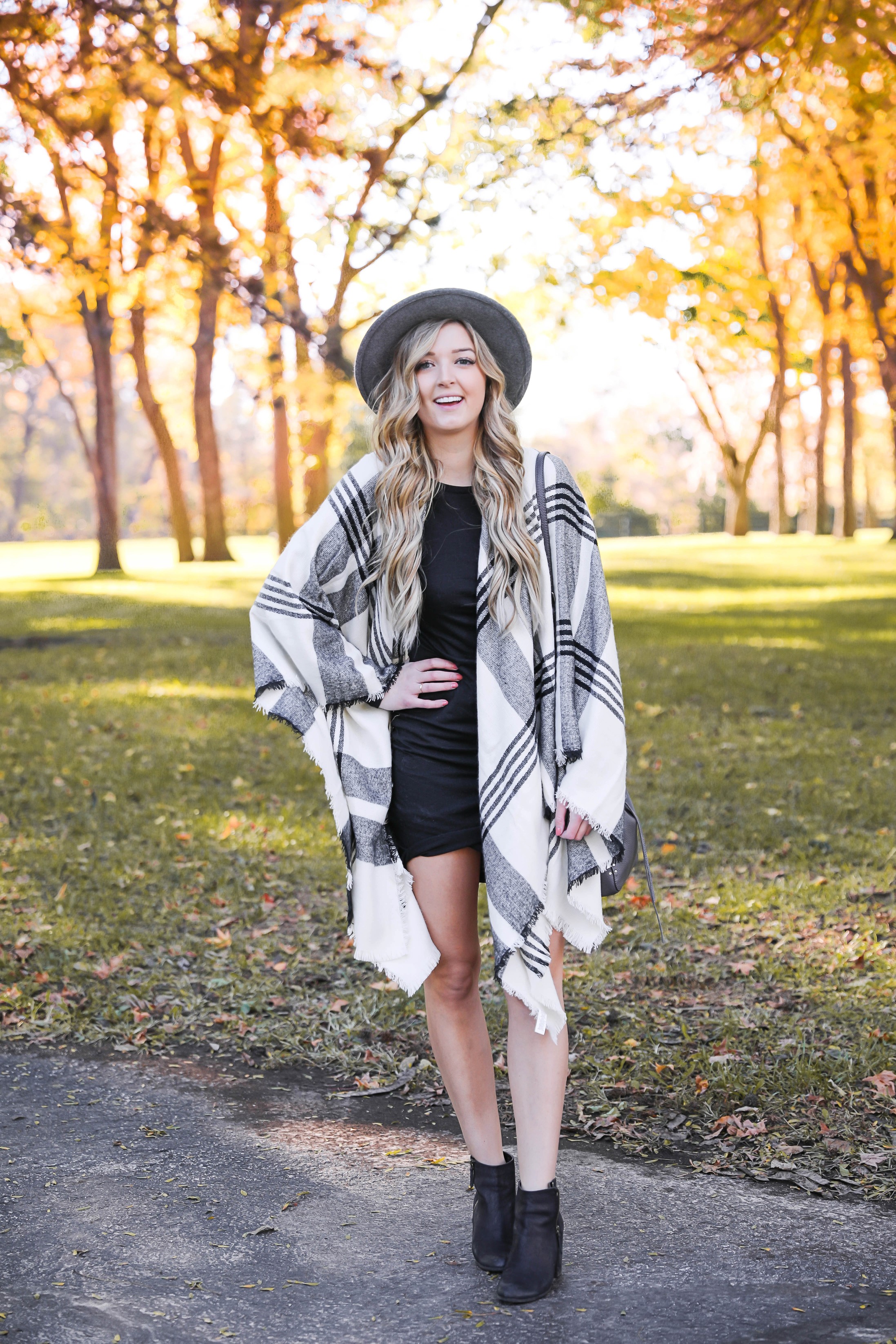 Plaid poncho wrapped around a tight black body con dress! I love these wraps for fall because they can double as scarves! This dress is by Leith from nordstrom and I am obsessed! Details on this fall fashion look and fall trees photoshoot can be found on fashion blog daily dose of charm by lauren lindmark