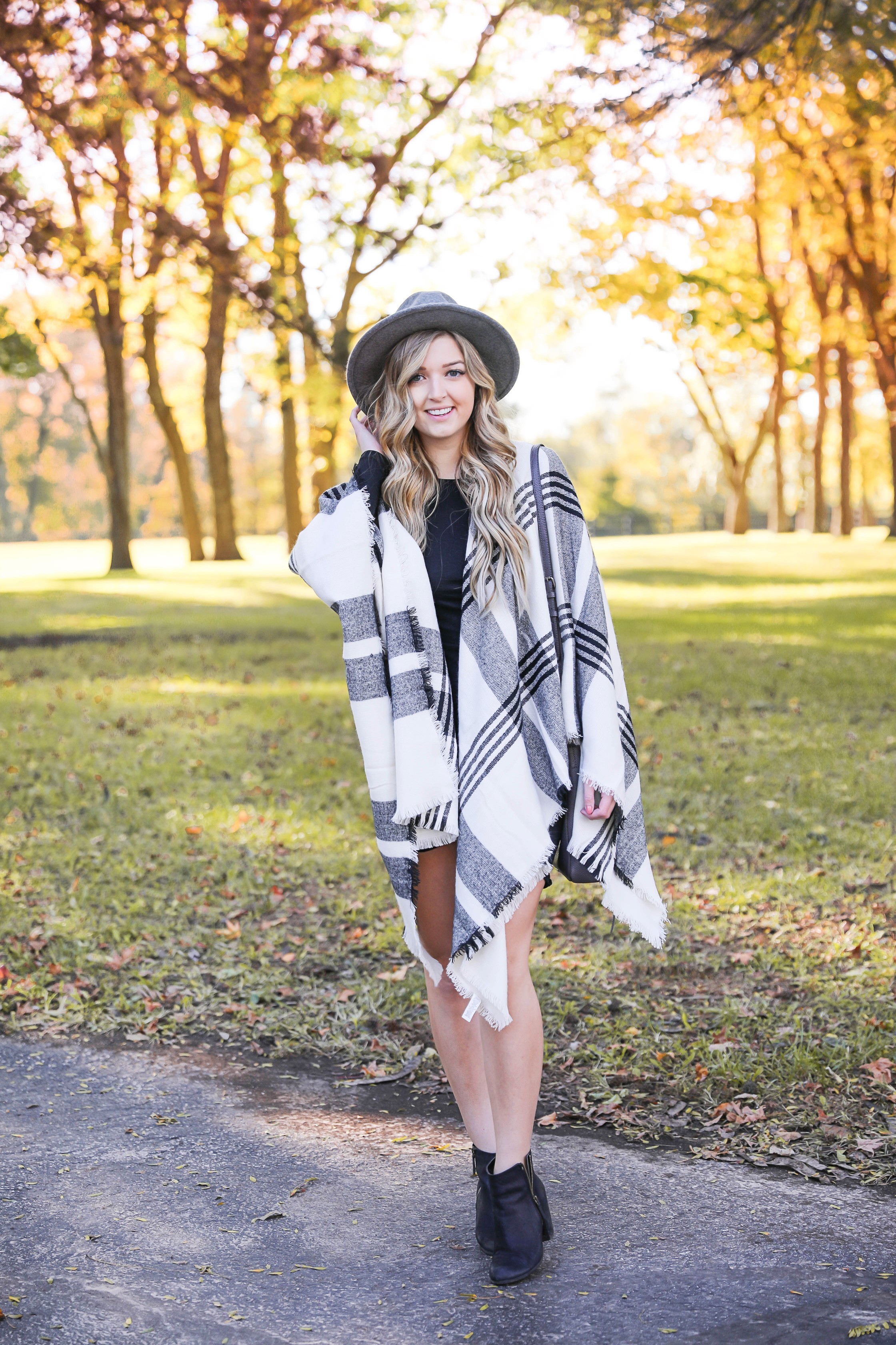 Plaid poncho wrapped around a tight black body con dress! I love these wraps for fall because they can double as scarves! This dress is by Leith from nordstrom and I am obsessed! Details on this fall fashion look and fall trees photoshoot can be found on fashion blog daily dose of charm by lauren lindmark