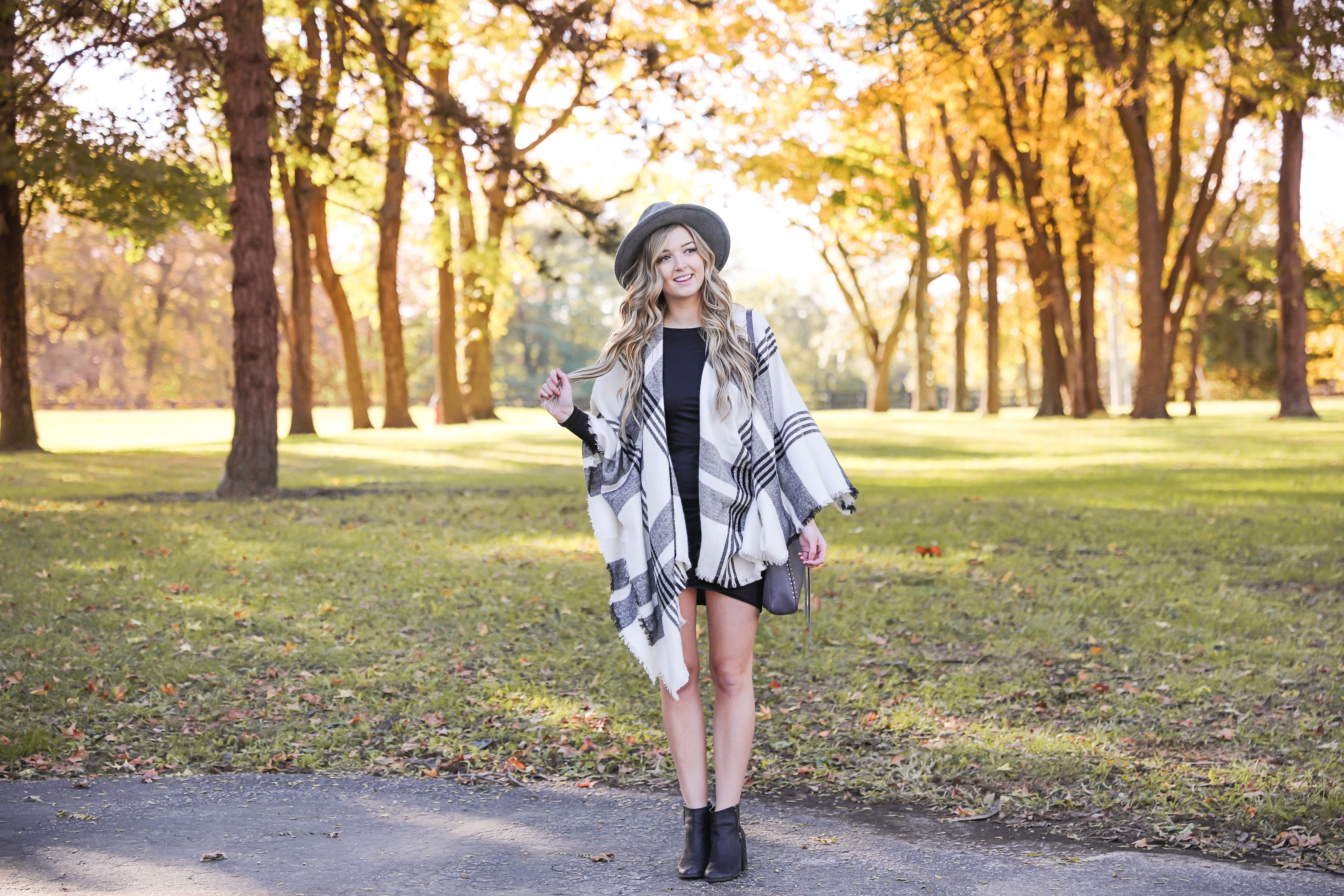 Plaid poncho wrapped around a tight black body con dress! I love these wraps for fall because they can double as scarves! This dress is by Leith from nordstrom and I am obsessed! Details on this fall fashion look and fall trees photoshoot can be found on fashion blog daily dose of charm by lauren lindmark