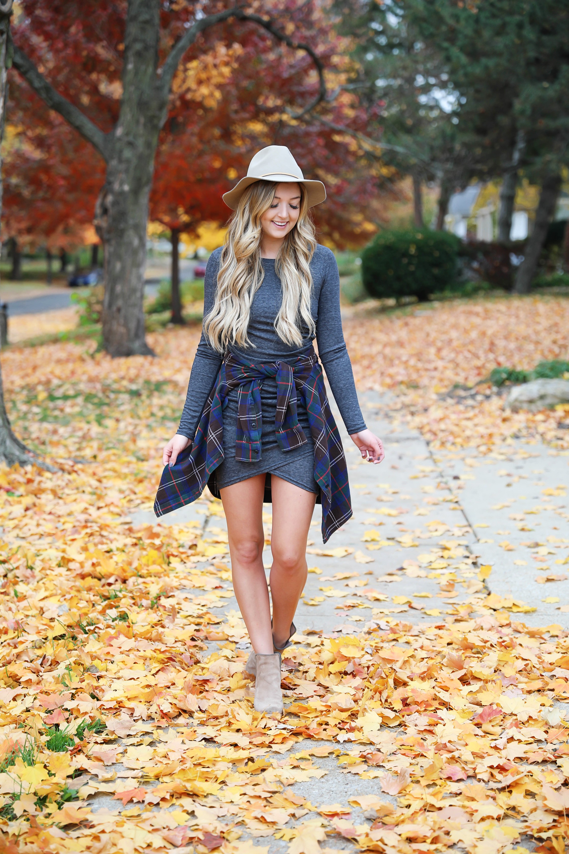 Gray long sleeve flattering dress with a cute flannel tied around the waist! These photos were taken in the prettiest fall leaves! I paired the outfit with this cute felt hat and suede booties! Details on fashion blog daily dose of charm by lauren lindmark