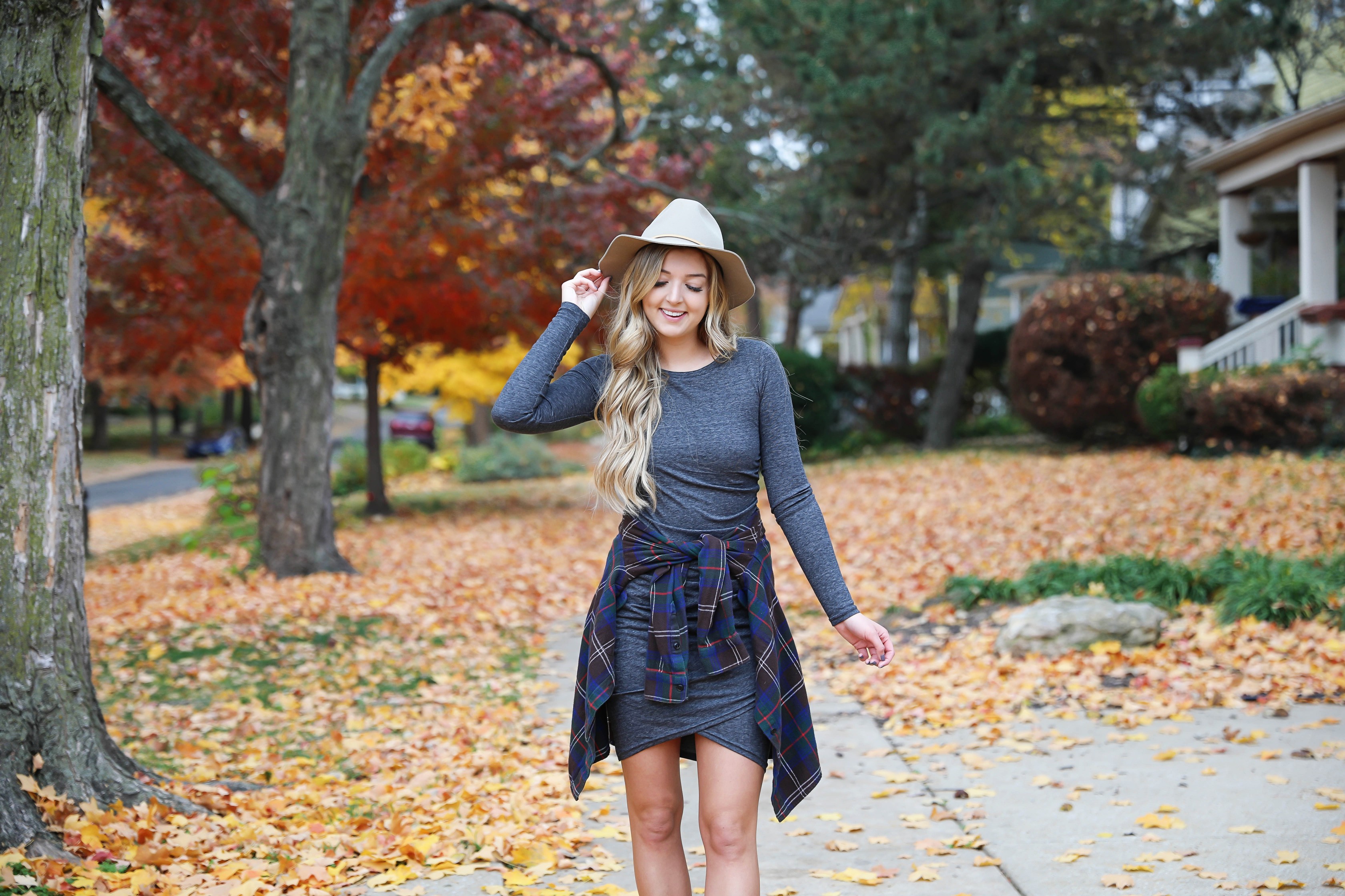 Gray long sleeve flattering dress with a cute flannel tied around the waist! These photos were taken in the prettiest fall leaves! I paired the outfit with this cute felt hat and suede booties! Details on fashion blog daily dose of charm by lauren lindmark