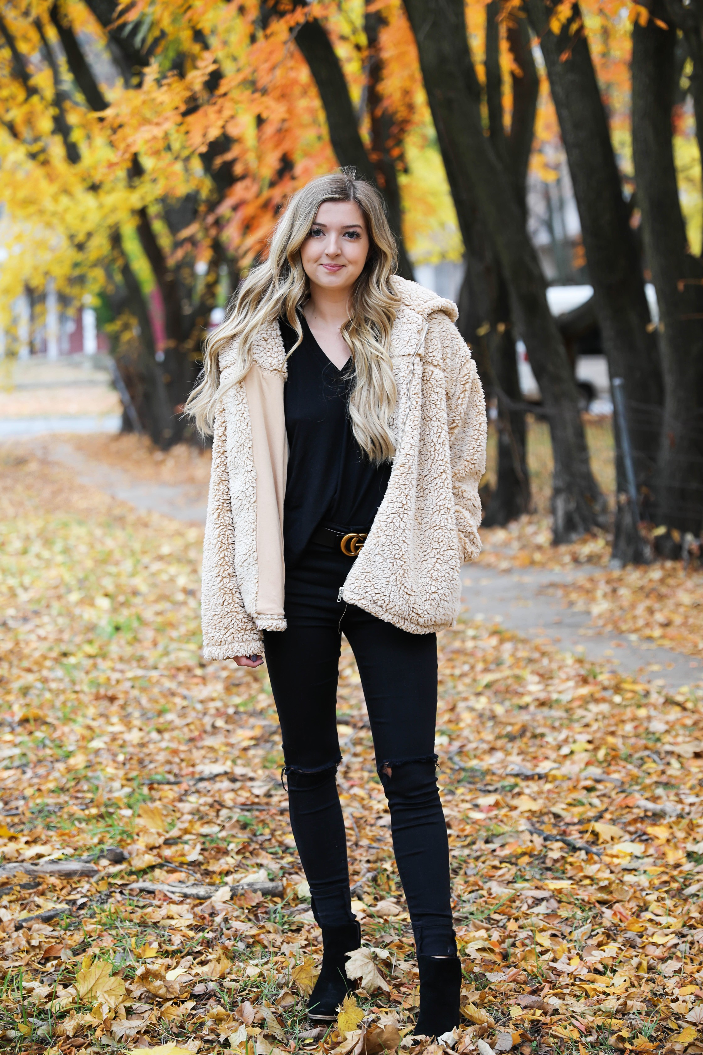 Teddy bear coat roundup! All the comfiest teddy bear fuzzy coats are linked on my blog! I paired mine with an all black outfit and my gucci belt! These are the prettiest photos taken in the fall leaves. Autumn trees are the best! Details on fashion blog daily dose of charm by lauren lindmark