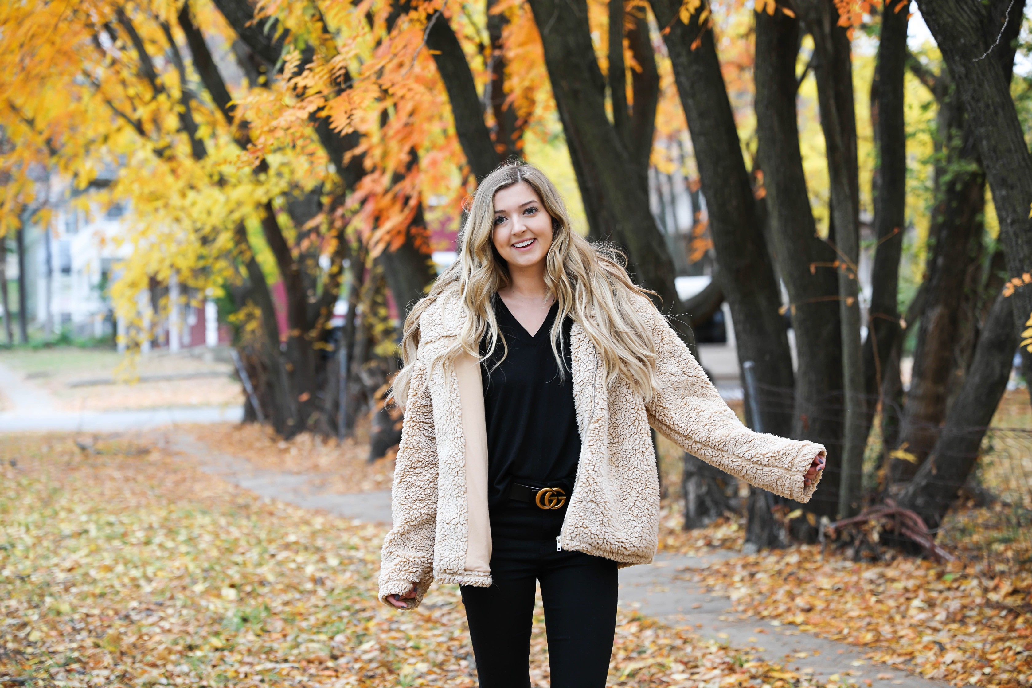 Teddy bear coat roundup! All the comfiest teddy bear fuzzy coats are linked on my blog! I paired mine with an all black outfit and my gucci belt! These are the prettiest photos taken in the fall leaves. Autumn trees are the best! Details on fashion blog daily dose of charm by lauren lindmark