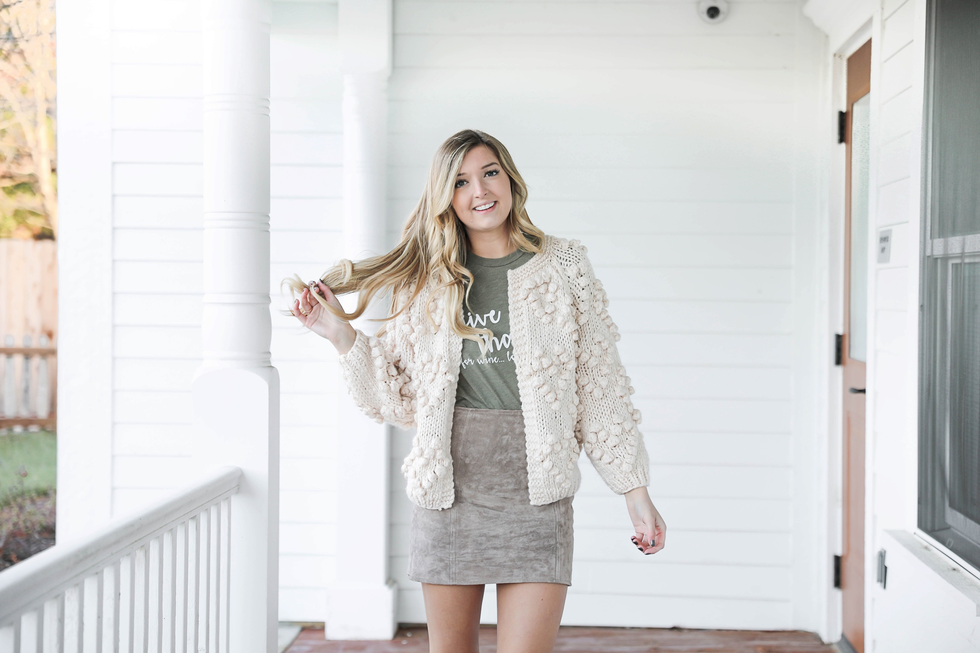 Thanksgiving outfit idea! Thanksgiving look, I love this t-shirt that says thankful for wine! The olive color shirt is so cute for this time of year and looks so good with the suede skirt and pom cardigan! Details on fashion blog daily dose of charm by lauren lindmark