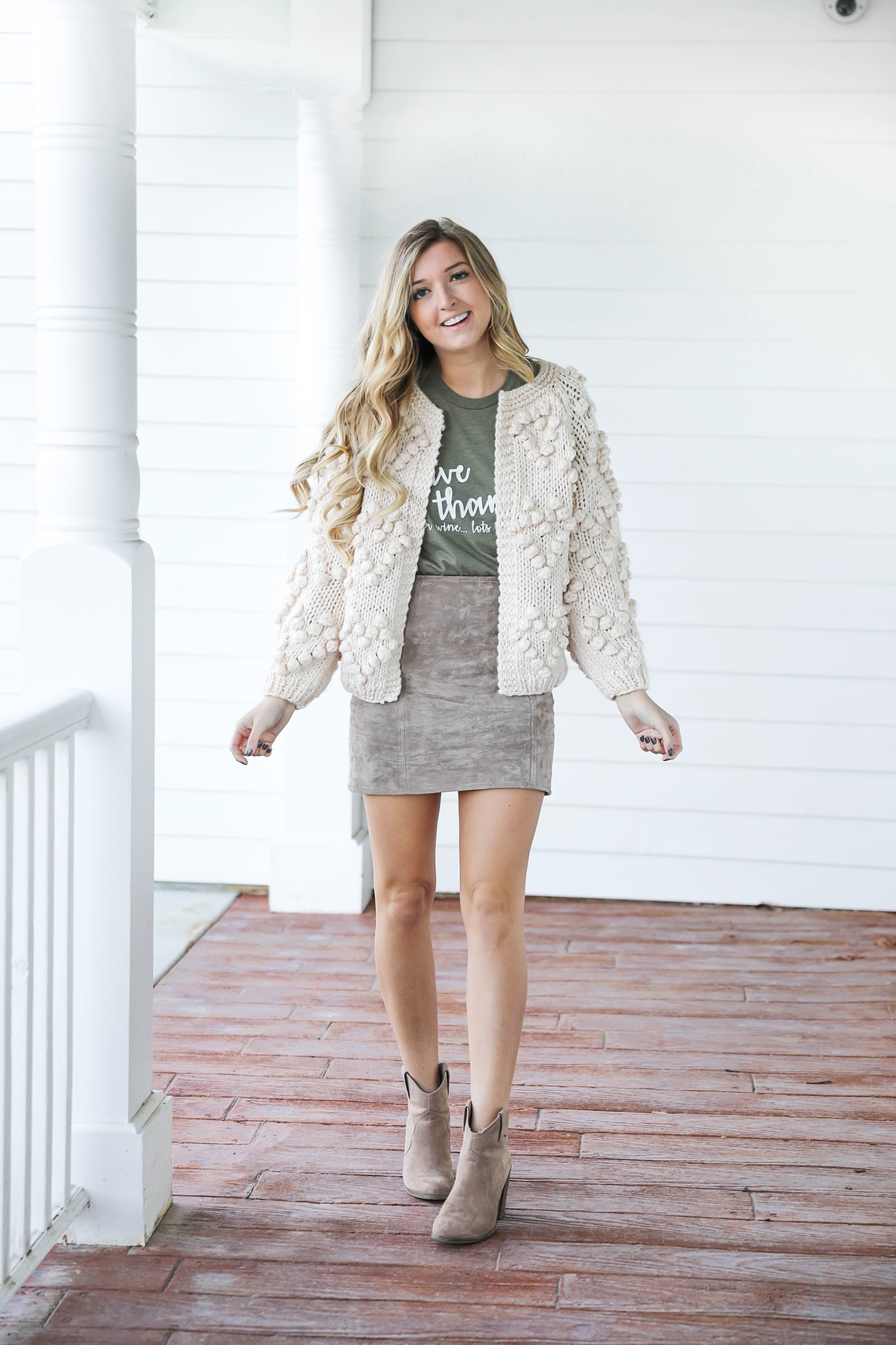 Thanksgiving outfit idea! Thanksgiving look, I love this t-shirt that says thankful for wine! The olive color shirt is so cute for this time of year and looks so good with the suede skirt and pom cardigan! Details on fashion blog daily dose of charm by lauren lindmark