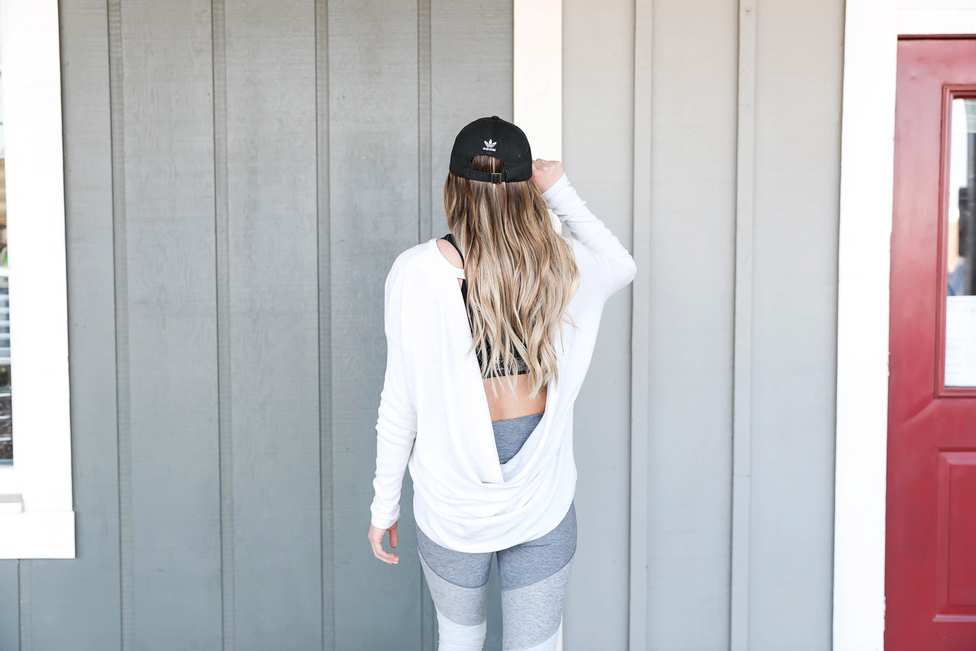 Cute New Year workout outfits for resolution inspiration in 2019! Stick to your fitness goals with a little outfit motivation! I love these color block leggings paired with the open back top and Adidas hat! Details on fashion blog daily dose of charm by lauren lindmark