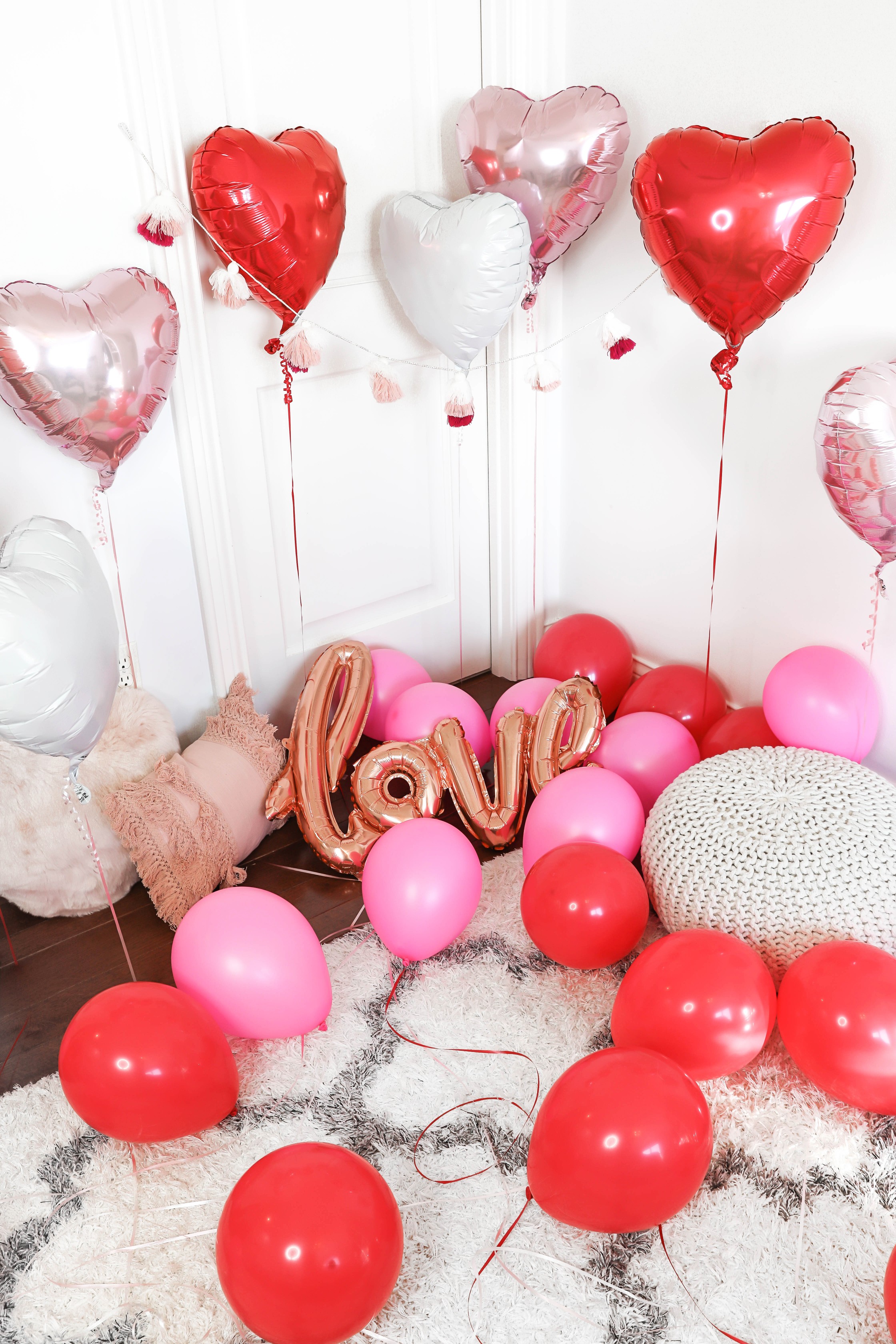 Valentine's Day shoot with the cutest heart shaped balloons and pink and red decor! My cute little pomeranian puppy dog made an appearance in the pics! I am wearing the cutest, tan, off the shoulder sweater from amazon and the cutest ripped denim from Red Dress Boutique! Details on style and fashion blog daily dose of charm by lauren lindmark